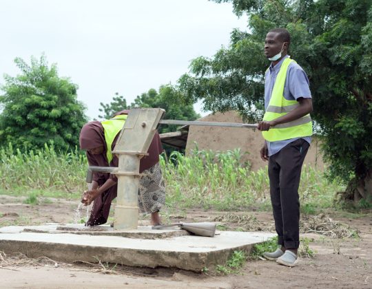 NGO Staff accessing a recently built borehole in their WaSH project